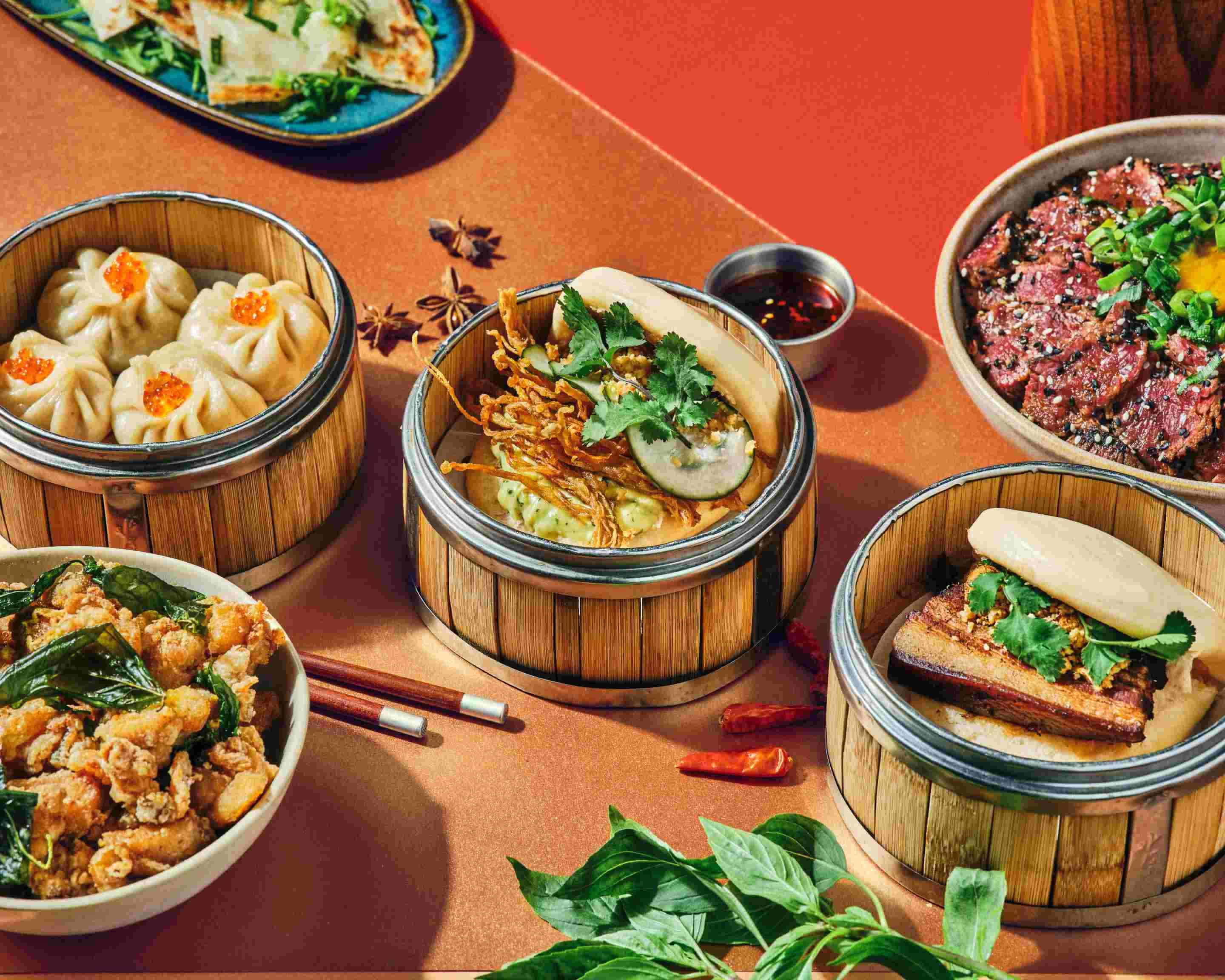 Table Bao City : paniers vapeur en bambou, nouilles, bœuf tataki et gua bao.